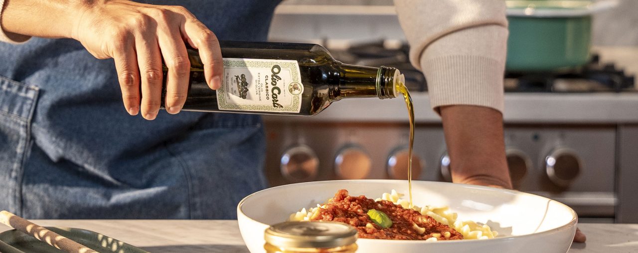 Verwendung des Olivenoel Classico zum Würzen eines Nudelgerichts mit Tomatensoße