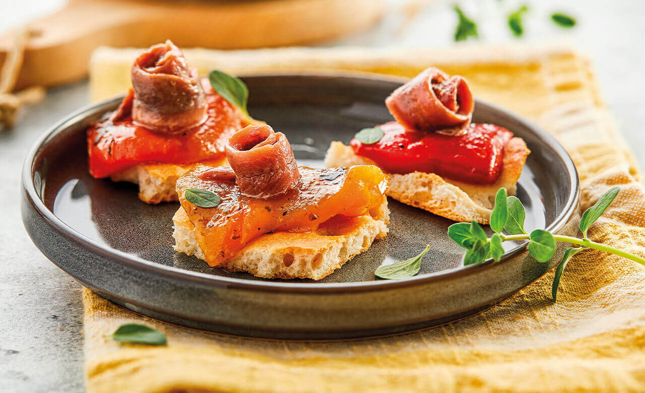 Poivrons grilles sur des morceaux de focaccia et anchois