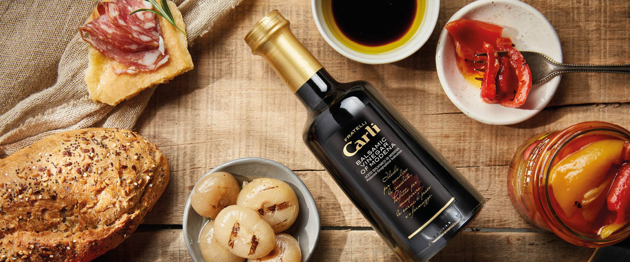 bouteille de vinaigre balsamique de Modène posée sur une table dressée 